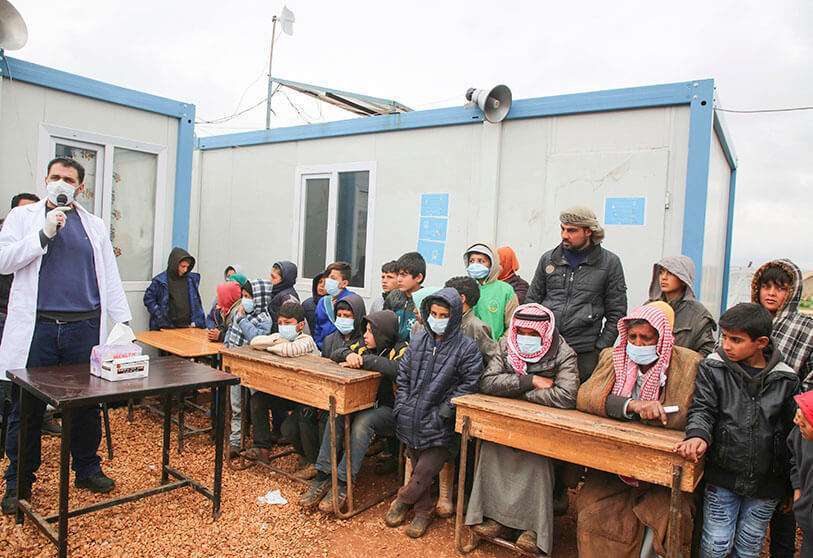 Un médico sirio lleva a cabo una campaña de sensibilización sobre cómo protegerse contra el coronavirus, en un campamento para personas desplazadas en Kafr Lusin, en la provincia noroccidental de Idlib