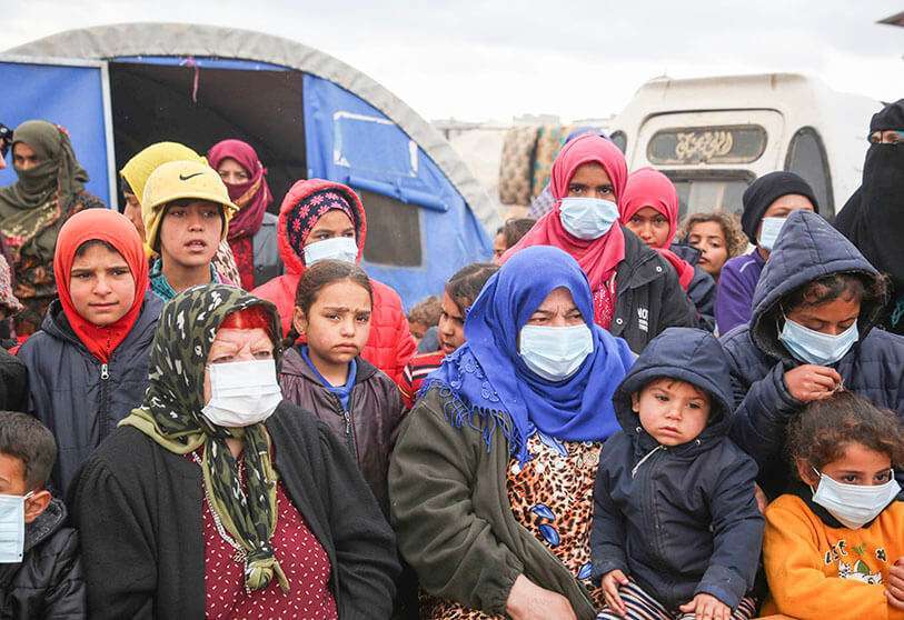 Sirios escuchan mientras los médicos llevan a cabo una campaña de concienciación sobre cómo protegerse contra el coronavirus, en un campamento en Kafr Lusin, en la provincia noroccidental de Idlib
