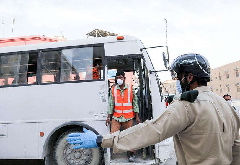 A police officer wears a smart helmet while checking the temperature of workers during the outbreak of COVID-19 disease in Dubai, United Arab Emirates on 23 April 2020
