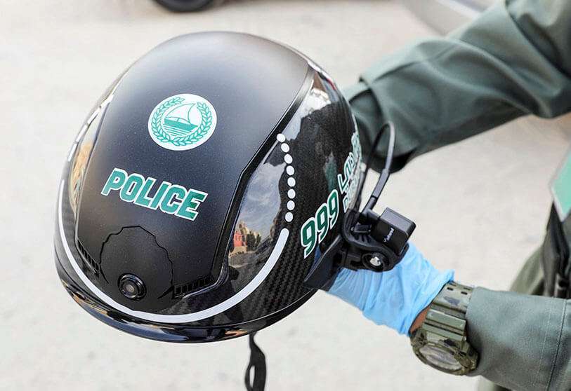 A police officer wears a smart helmet while checking the temperature of workers during the outbreak of COVID-19 disease in Dubai, United Arab Emirates on 23 April 2020