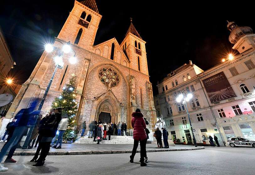 Los ciudadanos de Sarajevo, independientemente de su confesión, se reúnen para socializar frente a la Catedral del Corazón de Jesús para celebrar la Navidad con sus amigos y vecinos católicos, después de la Misa de Medianoche en Sarajevo, el 25 de diciembre de 2019