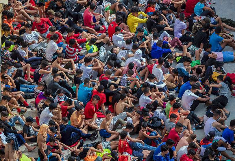 Niños que cruzaron a España esperan dentro de un refugio temporal para menores no acompañados en el enclave de Ceuta, junto a la frontera de Marruecos y España, el jueves 20 de mayo de 2021.  AP/BERNAT ARMANGUE