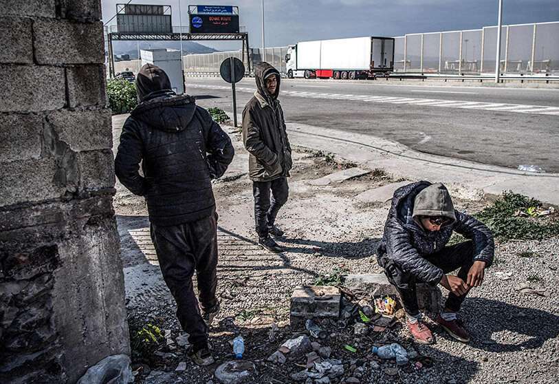 Jóvenes marroquíes esperan una oportunidad para entrar en el puerto de Tanger Med, para intentar cruzar a España el 14 de marzo de 2020, en la ciudad norteña de Tánger AFP/FADEL SENNA
