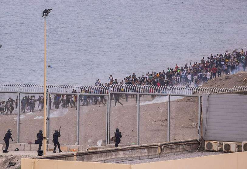 La policía española dispara gases lacrimógenos hacia los migrantes en la frontera entre España y Marruecos, junto al enclave español de Ceuta, el miércoles 19 de mayo de 2021 AP/BERNAT ARMANGUE