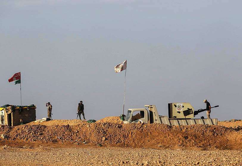 Fotografía de archivo del 12 de noviembre de 2018, combatientes chiíes iraquíes de la fuerza paramilitar Hashed al-Shaabi aseguran la zona fronteriza con Siria en al-Qaim, en la provincia iraquí de Anbar, frente a Albu Kamal en la región siria de Deir Ezzor