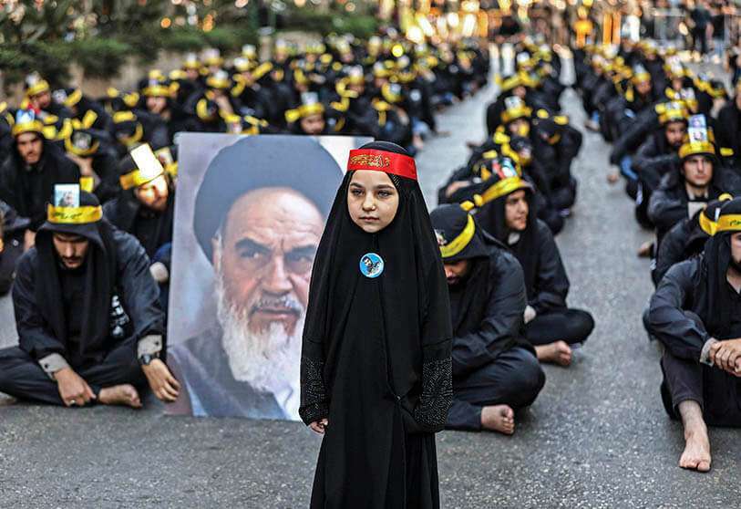 Los partidarios del movimiento chií libanés Hizbolá sostienen una imagen del difunto líder supremo de Irán, el Ayatolá Ruhollah Jomeini, mientras participan en una procesión de luto religioso el décimo día del mes lunar de Muharram, que marca el día de Ashura, en un suburbio de la capital Beirut, el 10 de septiembre de 2019