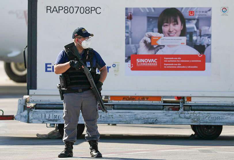 Un miembro de las fuerzas de seguridad monta guardia junto a los contenedores que transportan un lote de la vacuna COVID-19 de febrero de 2021 REUTERS/IVAN ALVARADO