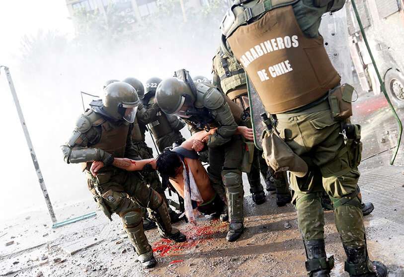 Un manifestante herido es llevado por miembros de las fuerzas de seguridad durante una protesta contra el gobierno de Chile en Santiago de Chile el 14 de noviembre de 2019.