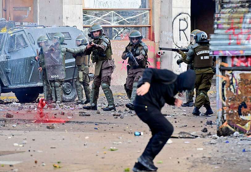 La policía antidisturbios apunta a un manifestante durante una protesta contra el gobierno y para conmemorar el primer aniversario de la muerte del líder indígena mapuche Camilo Castrillanca -muerto en un operativo policial- en Santiago, el 14 de noviembre de 2019.