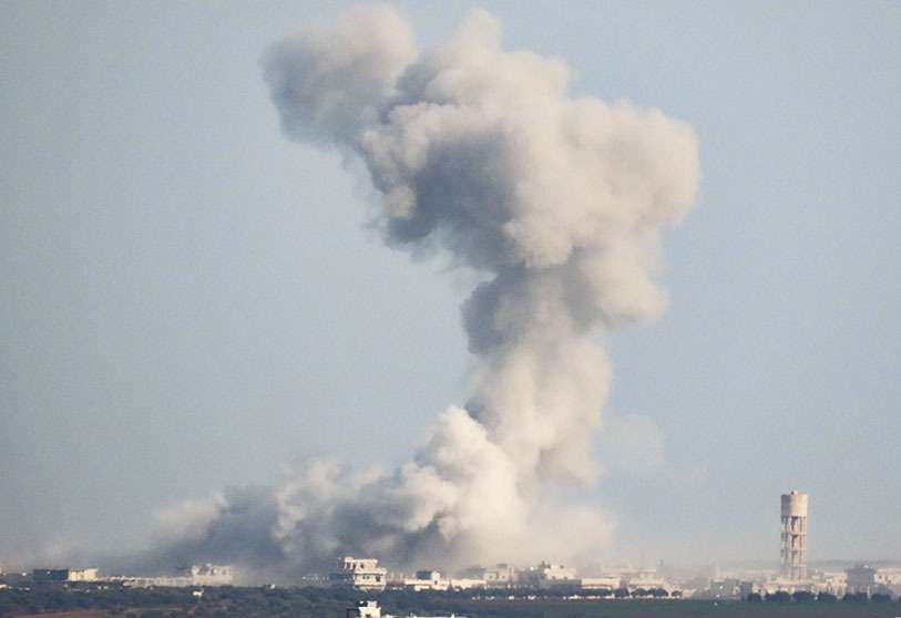 El humo se eleva por encima de los edificios durante los ataques aéreos de las fuerzas de Al-Asad sobre las zonas controladas por los rebeldes cerca de Saraqeb, retomada recientemente por Damasco