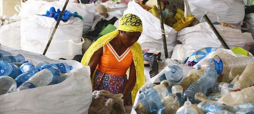 Una mujer examina bolsas de plástico desechadas en Côte d'Ivoire
