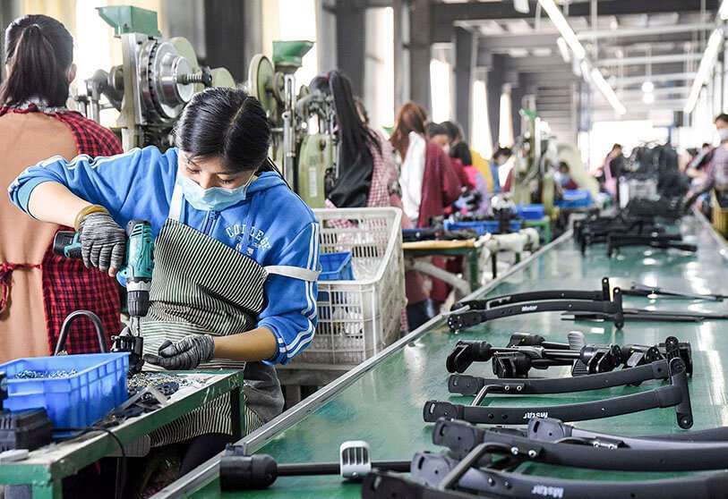 Cette photo prise le 29 avril 2020 montre des ouvriers produisant des poussettes dans une usine à Handan, dans la province de Hebei, au nord de la Chine