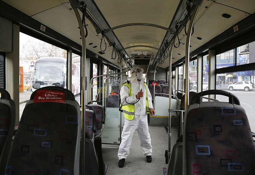 Un trabajador municipal con un traje protector rocía desinfectante en un autobús en Estambul, en medio del brote de coronavirus, el 3 de abril de 2020