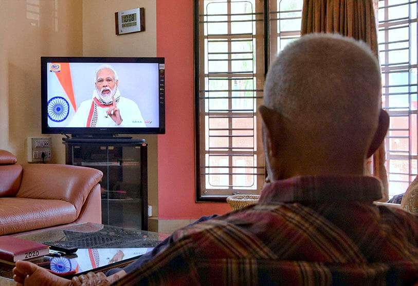 Una persona mayor observa al primer ministro indio Narendra Modi dirigirse a la nación en un programa de televisión, en Bangalore el 14 de abril de 2020