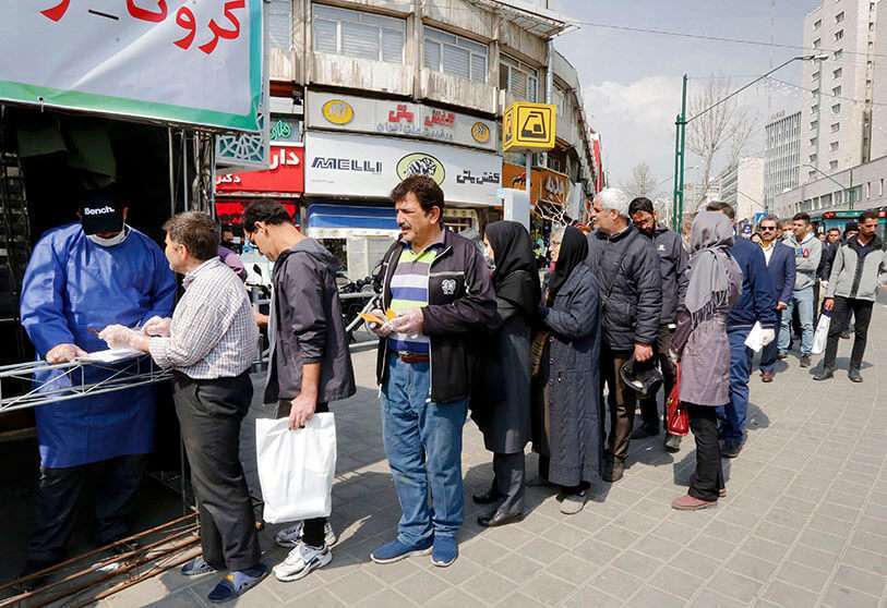 La gente hace cola para recibir los paquetes de precauciones contra el coronavirus proporcionados por los Basij, una milicia leal al establecimiento de la República Islámica de Irán, en la capital, Teherán, el 15 de marzo de 2020