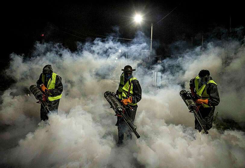 Voluntarios del Equipo de Rescate de Sonko, una ONG financiada privadamente por el Gobernador de Nairobi Mike Sonko, fumigan una calle para frenar la propagación de la COVID-19