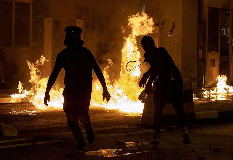 Los manifestantes lanzan cócteles molotov en la caseta de peaje del túnel Cross Harbor, cerca del campus de la Universidad Politécnica de Hong Kong en Hong Kong, el jueves 14 de noviembre de 2019