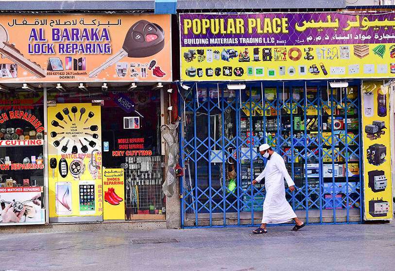 Un hombre camina por tiendas cerradas en Dubái en medio de medidas para frenar la propagación del coronavirus (COVID-19), el 25 de marzo de 2020