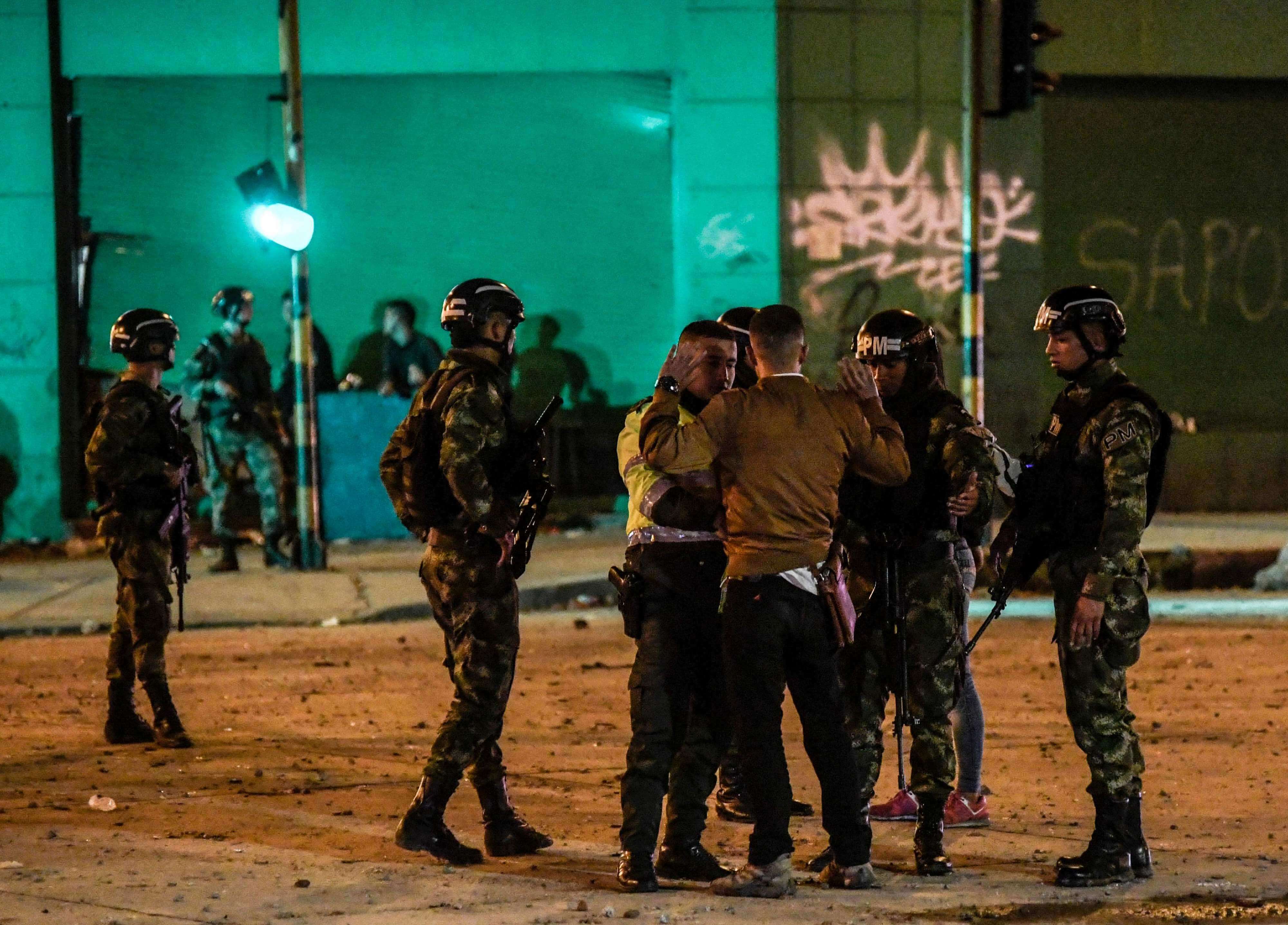 Soldados del Ejército colombiano detienen a un hombre mientras la gente protesta en la carretera norte de Bogotá, el 22 de noviembre de 2019