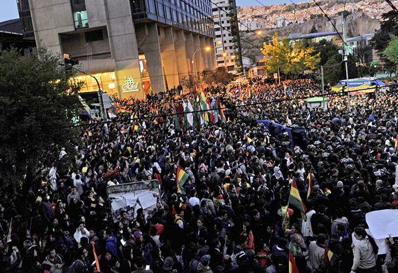 Los partidarios del candidato presidencial de la oposición boliviana al partido Comunidad Ciudadana, el expresidente Carlos Mesa, y del presidente y candidato Evo Morales, son separados por las fuerzas de seguridad cuando se reúnen frente al hotel donde el Tribunal Supremo Electoral tiene su sede para contar los votos electorales, en La Paz, el 21 de octubre de 2019