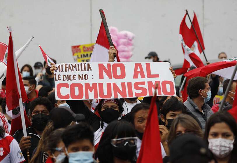 Un partidario de la candidata presidencial Keiko Fujimori sostiene un cartel con un mensaje que dice en español: "Mi familia dice, No al Comunismo" durante una protesta contra el presunto fraude electoral, en Lima, Perú, el sábado 12 de junio de 2021