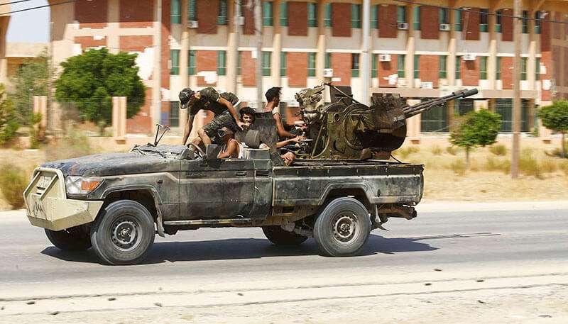Combatientes del Gobierno de Acuerdo Nacional (GNA) a bordo de un vehículo militar durante los enfrentamientos con las fuerzas leales al hombre fuerte Jalifa Haftar, en Espiaa, a unos 40 kilómetros (25 millas) al sur de la capital libia, Trípoli, el 21 de agosto de 2019