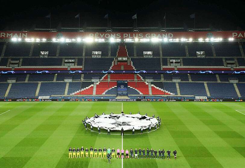 Jugadores del París Saint-Germain y del Borussia de Dortmund en el estadio vacío del Parque de los Príncipes antes del partido de fútbol de octavos de final de la Liga de Campeones