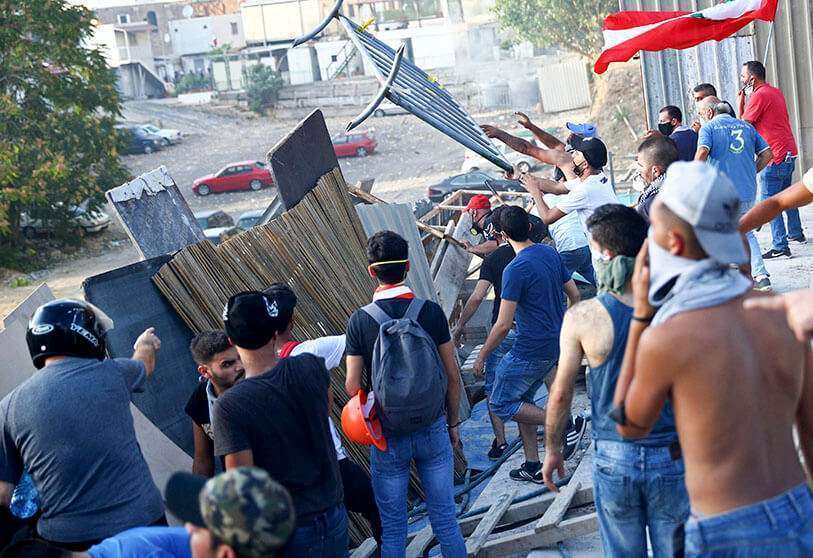 PHOTO/REUTERS - Los manifestantes quitan la barricada durante una protesta tras la explosión del martes, en Beirut, Líbano, el 8 de agosto de 2020