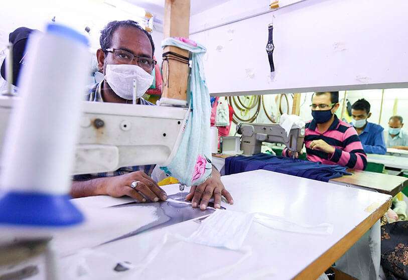 Trabajadores cosen máscaras de protección y prendas sanitarias en una fábrica de Sharjah, en los Emiratos Árabes Unidos, el 26 de marzo de 2020, en medio de la pandemia del coronavirus COVID-19