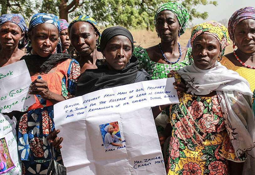 Familiares sostienen retratos de sus niñas durante una conmemoración cinco años después de que fueron secuestradas por Boko Haram en Chibok