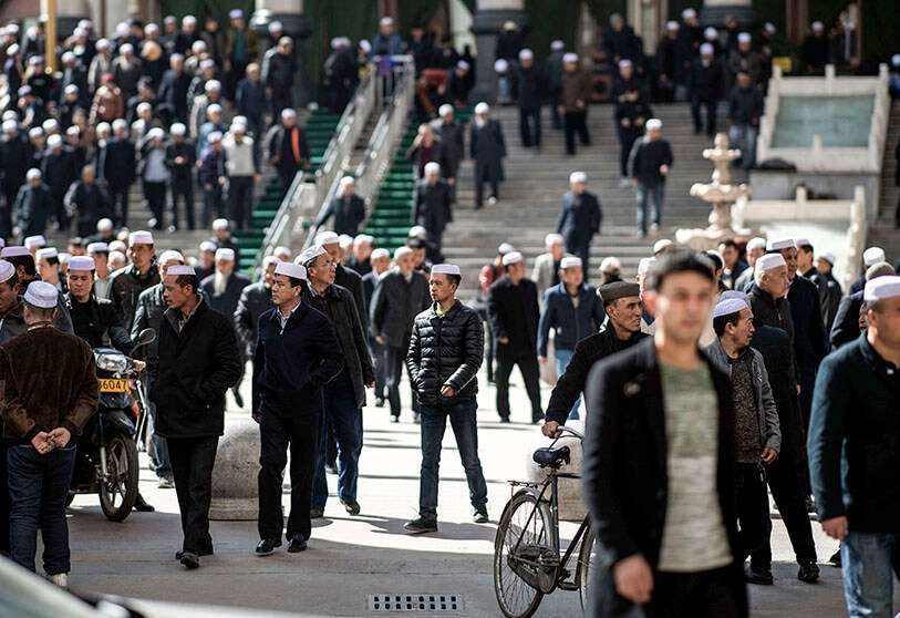 Hombres musulmanes de etnia Hui saliendo de la mezquita de Laohuasi después de las oraciones del viernes en Linxia, provincia china de Gansu