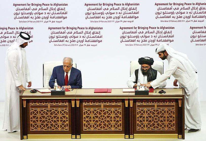 AFP/KARIM JAAFAR - US Special Representative for Afghanistan Zalmay Khalilzad and Taliban co-founder Mullah Abdul Ghani Baradar sign the agreement in Doha.