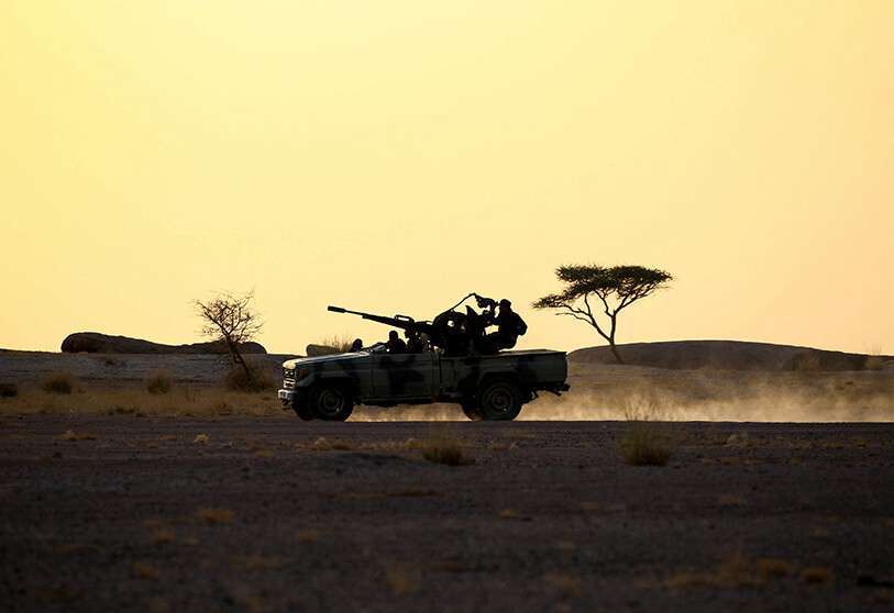 Miembros del Frente Polisario conducen una camioneta con un arma antiaérea al atardecer en Bir Lahlou, Sáhara Occidental