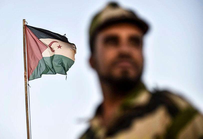 Un soldado uniformado del Frente Polisario, pro-independentista, están ante una bandera saharaui ondeando en la ciudad de Bojador, en el territorio en disputa del Sáhara Occidental, el 17 de octubre de 2017, al oeste de la ciudad argelina de Tinduf