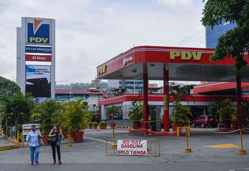 La gente pasa por delante de una gasolinera con un cartel que dice "No hay gasolina", debido a la falta de petróleo en Caracas, el 14 de mayo de 2020 en medio del brote del coronavirus