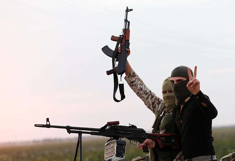 Unos combatientes rebeldes sirios respaldados por Turquía viajan en un camión para cruzar a Siria, cerca de la ciudad fronteriza de Akcakale, en la provincia de Sanliurfa, Turquía, el 17 de octubre de 2019