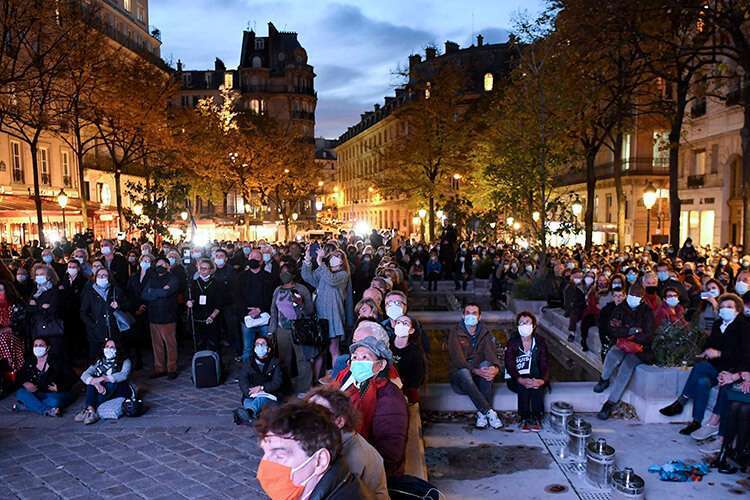 La gente se reúne en la Plaza de la Sorbona de París el 21 de octubre de 2020 para ver en una pantalla gigante la transmisión en directo de un homenaje nacional en la Universidad de la Sorbona al profesor francés Samuel Paty