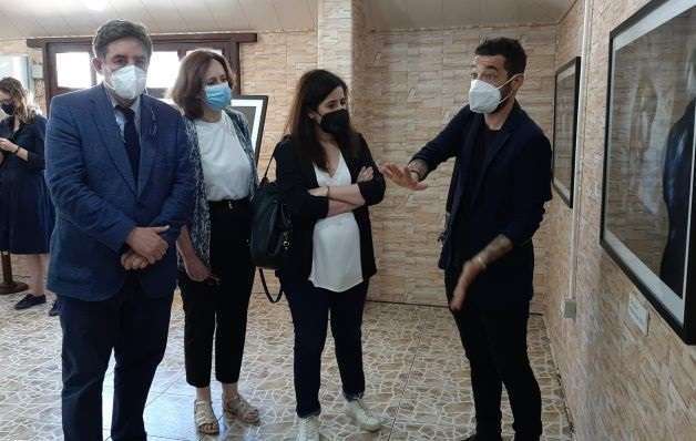 El fotoperiodista Diego Ibarra Sánchez explica las imágenes expuestas en la muestra ‘En primera línea’, sobre los efectos de la guerra en la educación, a Luis García Montero, Carmen Noguero (centro) y la directora de Cultura del Cervantes, Raquel Caleya