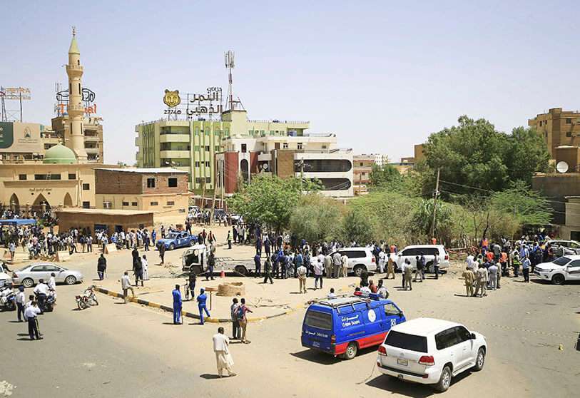 Equipos de rescate y fuerzas de seguridad sudanesas se reúnen junto a un vehículo dañado en el lugar de un intento de asesinato contra el primer ministro de Sudán, Abdalla Hamdok