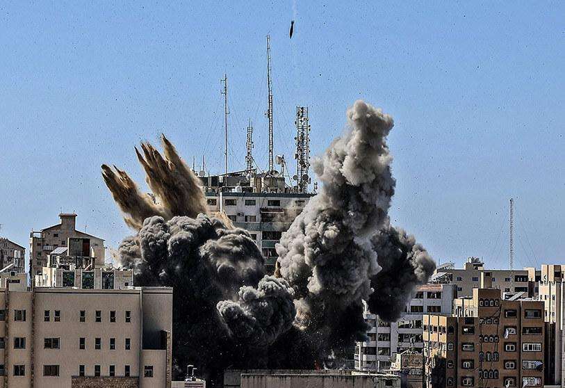 AP/MAHMUD HAMS - En esta foto de archivo del sábado 15 de mayo de 2021, una bomba aérea alcanza el edificio que alberga varios medios de comunicación internacionales, entre ellos The Associated Press, en la ciudad de Gaza