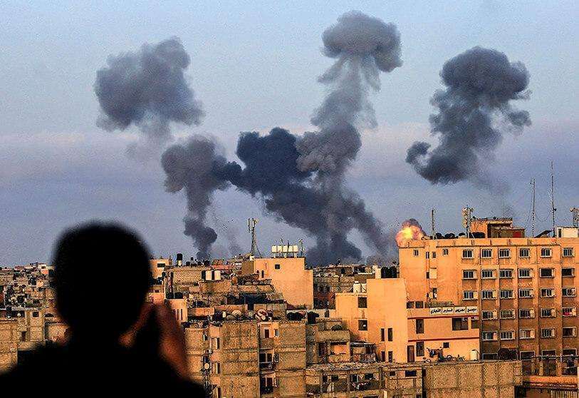 FP/MAHMOUD KHATAB - Un niño palestino observa el humo que sale de los objetivos durante los ataques aéreos israelíes en la región de Khan Yunis, al sur de Gaza, controlada por el movimiento Hamás, el 11 de mayo de 2021. - Israel lanzó mortíferos ataques aéreos sobre Gaza en respuesta a una andanada de cohetes lanzados por el movimiento islamista Hamás