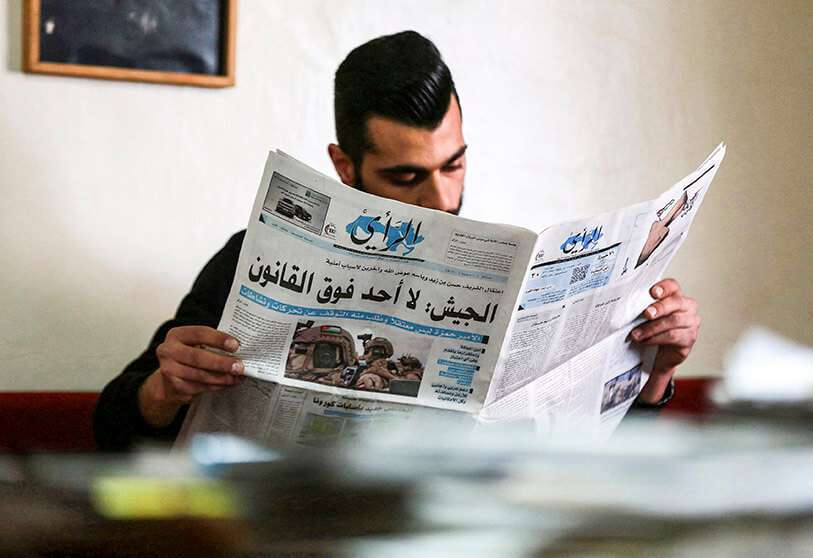 Un ciudadano jordano lee un periódico local con un titular en su portada sobre los últimos acontecimientos en su país, en la capital, Ammán, el 4 de abril de 2021. - AFP/KHALIL MAZRAAWI