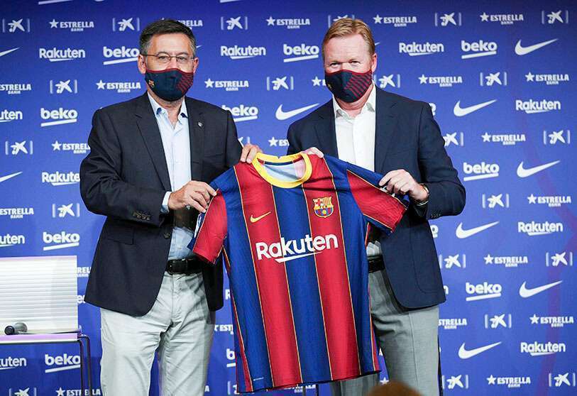 L'entraîneur du FC Barcelone, Ronald Koeman, pose avec le président Josep Maria Bartomeu et un T-shirt pendant la présentation
