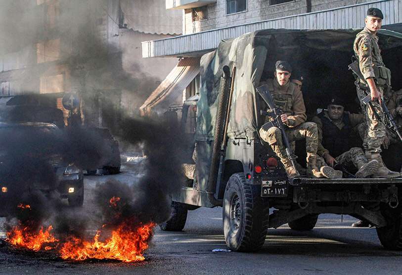 Efectivos del Ejército pasan junto a los restos de una barricada en Sidón
