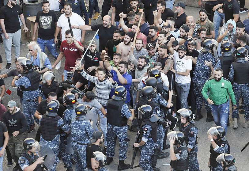 En la foto de archivo, la policía antidisturbios intenta detener a los partidarios del grupo chiíta de Hizbulá, que llegaron a quemar y destruir tiendas de campaña en el campamento establecido por manifestantes antigubernamentales cerca del palacio de gobierno, en Beirut, Líbano
