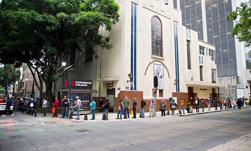 La gente hace cola para recibir alimentos entregados por voluntarios de la comunidad religiosa de Sant'Egidio en Ciudad de México, el 10 de junio de 2020, en medio de la pandemia de coronavirus