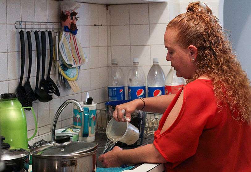 La venezolana Carolina Bohorquez (45), lava platos con agua recogida de contenedores en su casa de Maracaibo, Venezuela, el 25 de mayo de 2020 durante la pandemia de coronavirus