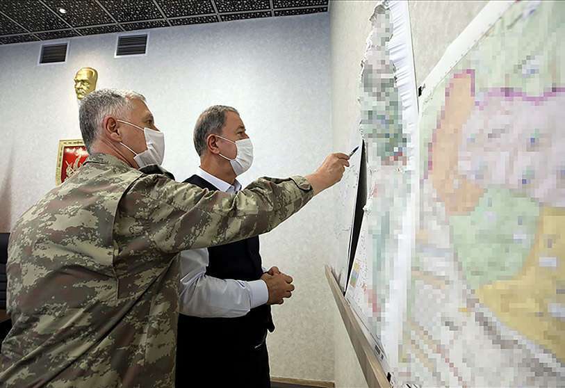 Una imagen facilitada por la Oficina de Prensa del Ministerio de Defensa turco el 17 de junio de 2020, muestra al Ministro de Defensa turco Hulusi Akar (R) mirando un mapa con miembros del Mando de las Fuerzas Armadas turcas durante una reunión en el Centro de Control del Mando del Ejército en Ankara durante la operación militar apodada "Claw-Tiger" el 17 de junio de 2020. AFP PHOTO /Turkish Ministry of Defense Press Office