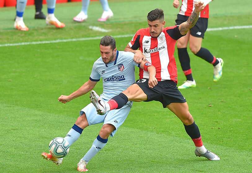 El centrocampista del Atlético de Madrid Koke (I) compite con el defensa del Athletic de Bilbao Yuri Berchiche durante el partido de fútbol de la Liga española entre el Athletic Club de Bilbao y el Club Atlético de Madrid en el estadio San Mamés de Bilbao, el 14 de junio de 2020