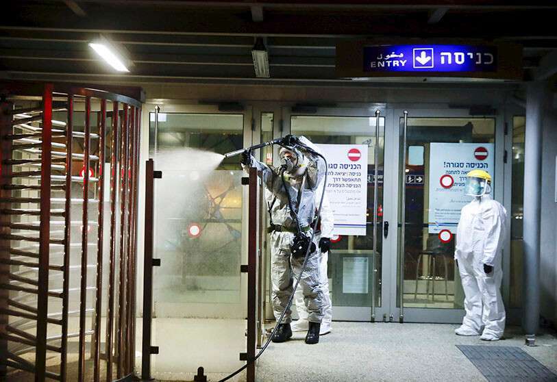 Un bombero rocía desinfectante como precaución contra el coronavirus en la estación de tren Moshe Dayan en Rishon LeTsiyon, Israel, el domingo 22 de marzo de 2020